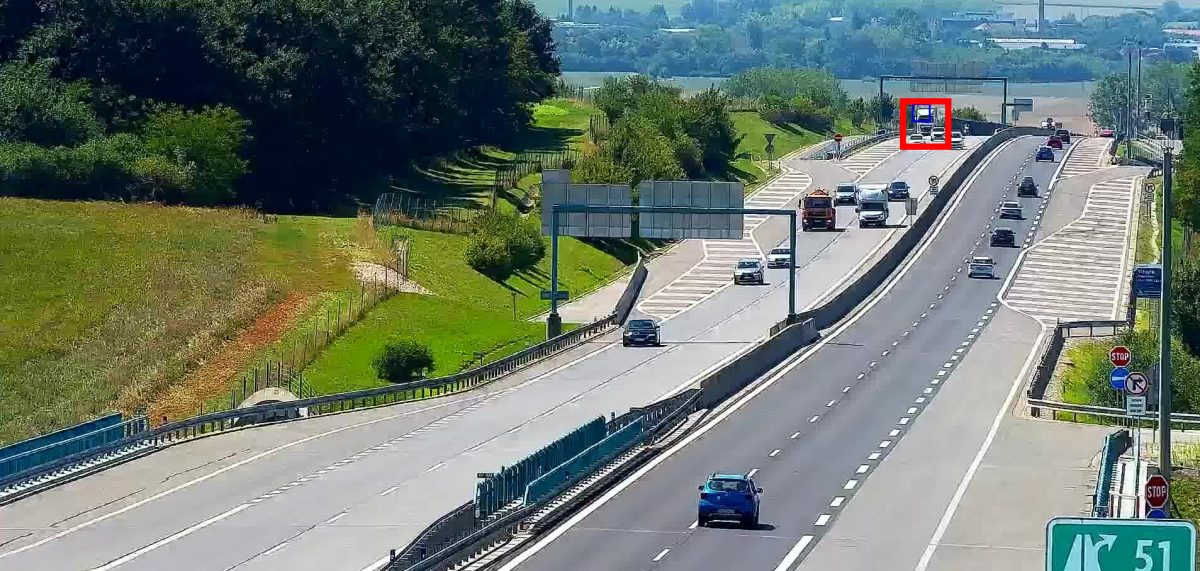Distant stopped vehicle detected far from the traffic camera on a busy expressway