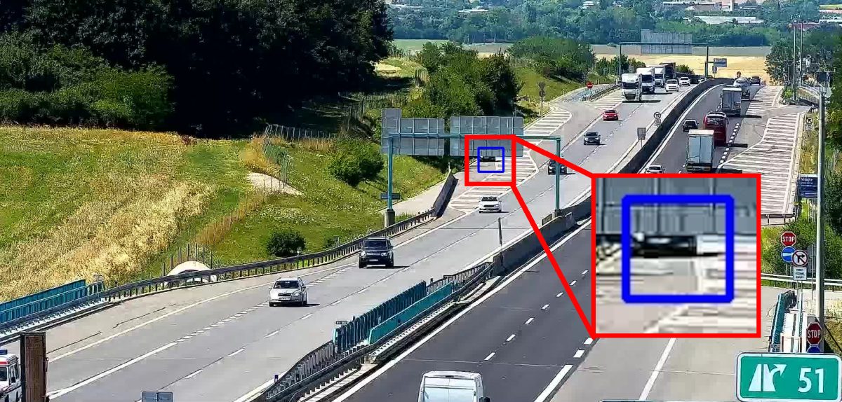 Stopped car partly hidden behind an overhead road sign, shown enlarged