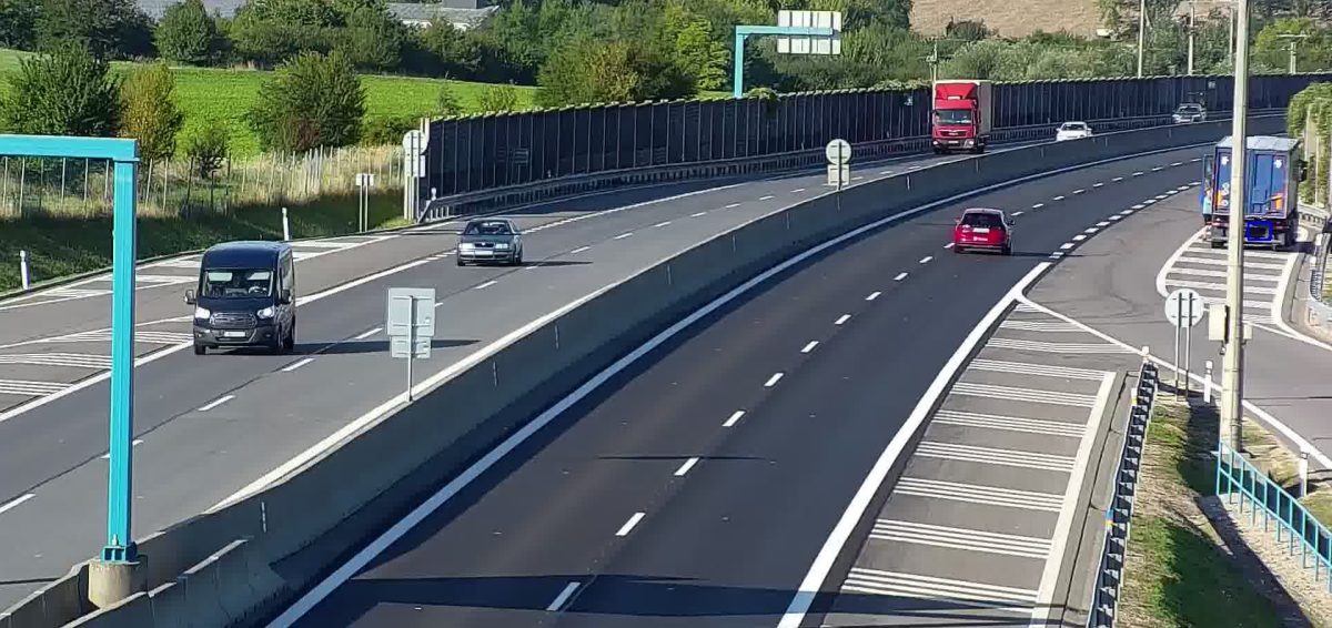 Large truck stopped on the hard shoulder of an expressway next to a noise barrier