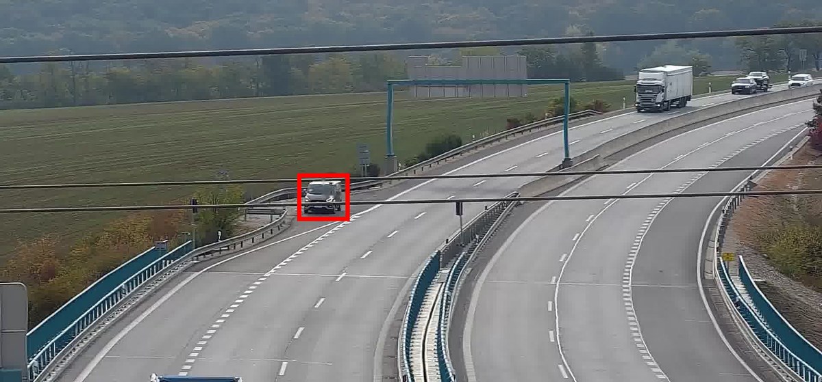Van stopped at the edge of a slip road, with overhead cables crossing the camera view