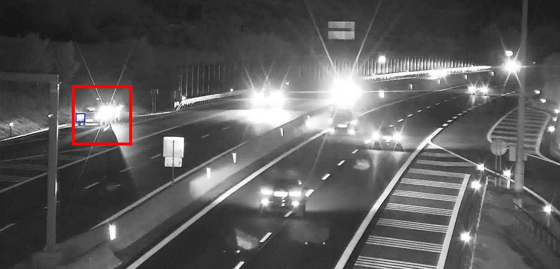 Stojící auto detekované v noci na rychlostní silnici vedle oslnění protijedoucími světlomety