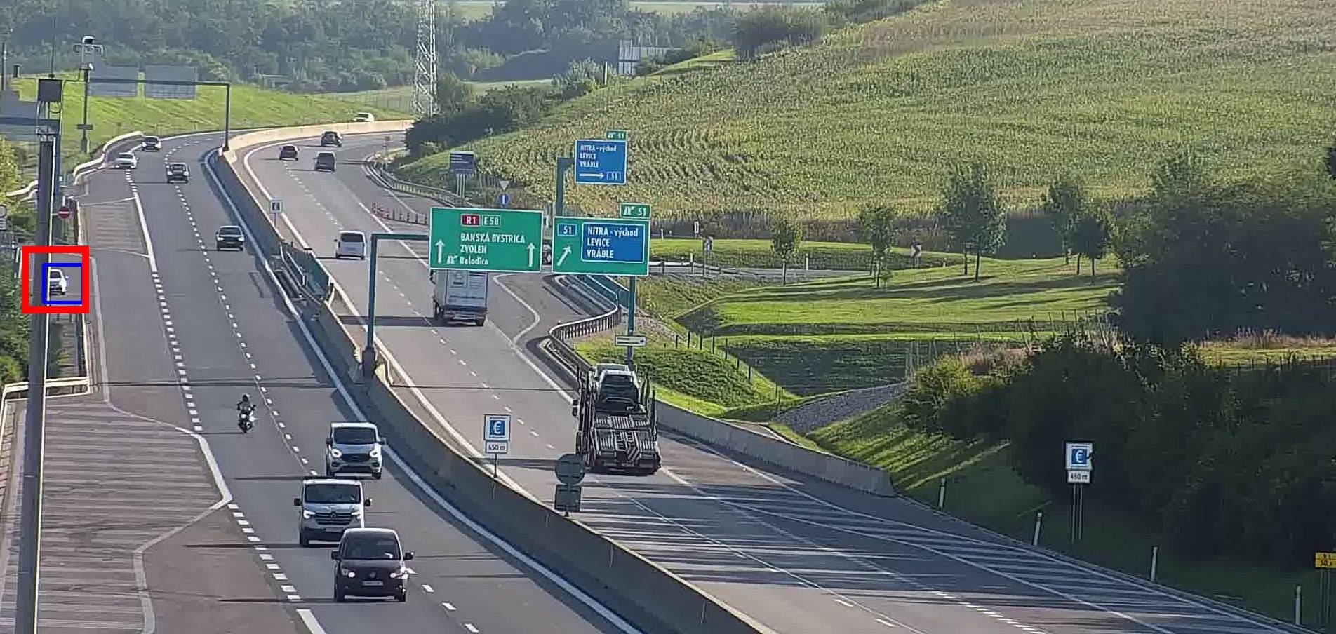 Vehicle stopped at the edge of the expressway, partly hidden by a lamp post