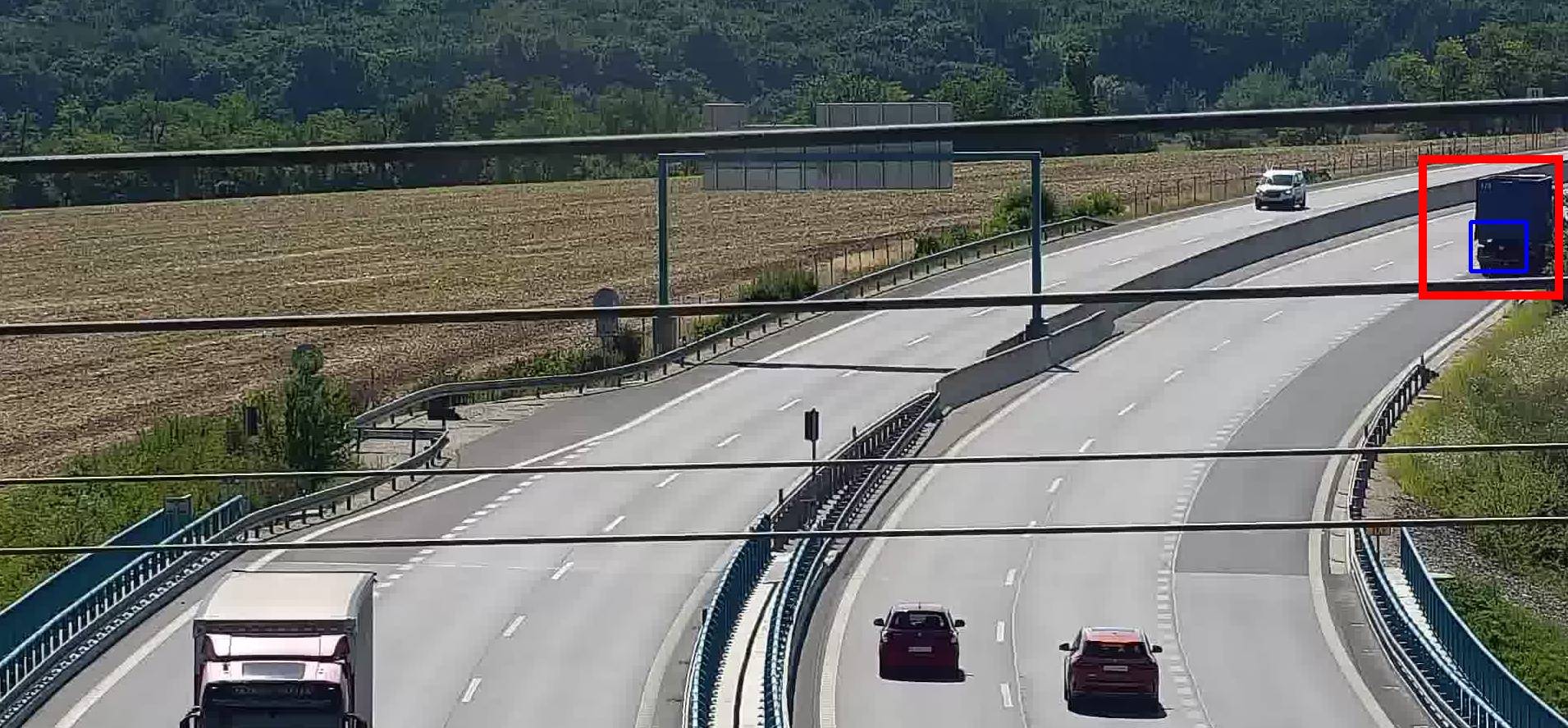 Stopped truck detected at the edge of the camera view on a curved expressway