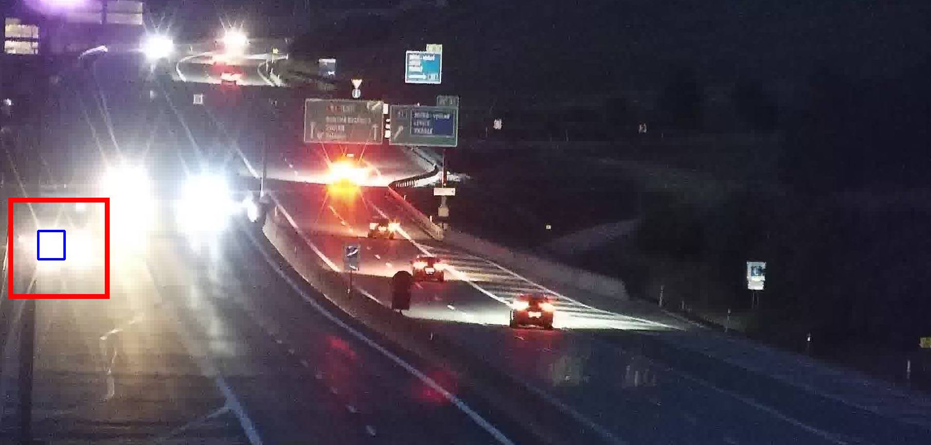 Vehicle stopped on the hard shoulder at night, detected next to oncoming headlights